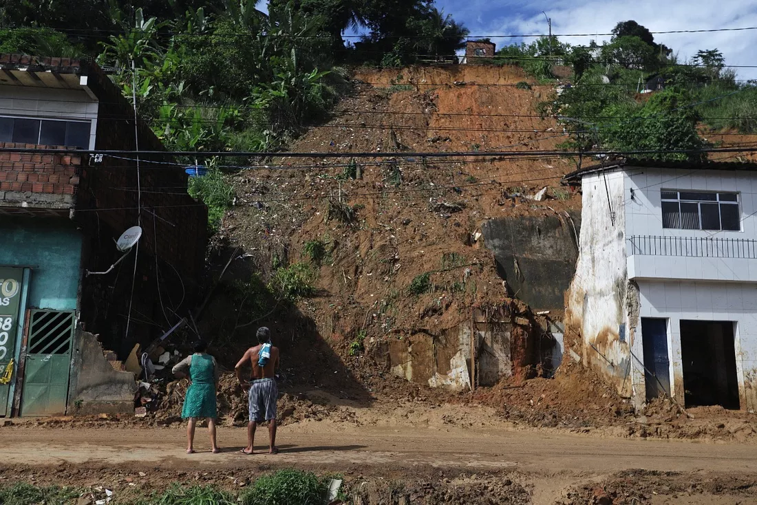  Casal observa barreira que caiu por cima de casas em Pernambuco - Foto: Sérgio Maranhão/AFP