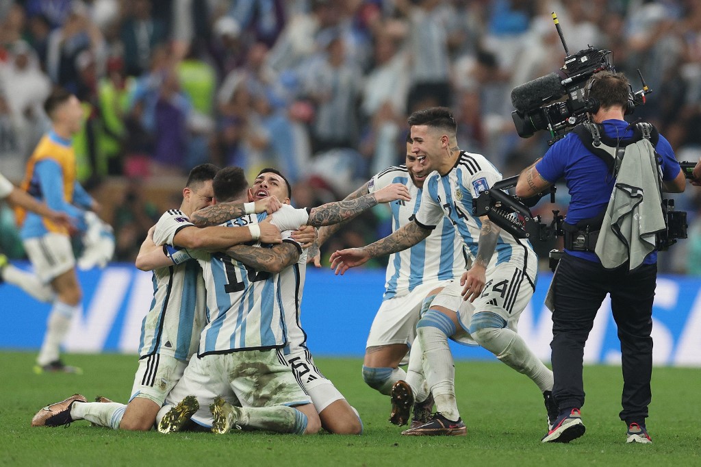 Messi, celebrando o título da Copa do Mundo com os companheiros - Foto: Adrian Dennis/AFP